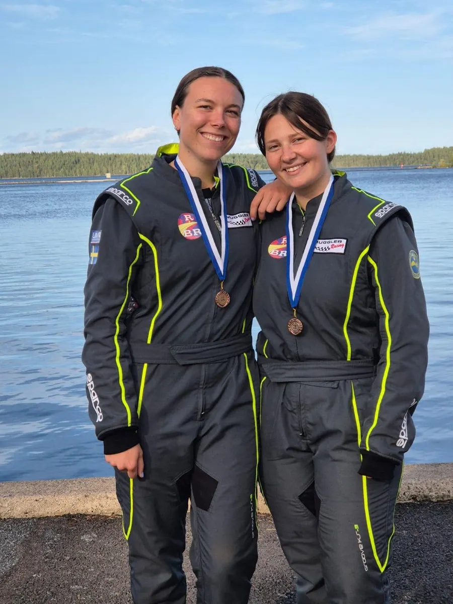 Lina Hamren and Wilma Jansson in race suits with medals