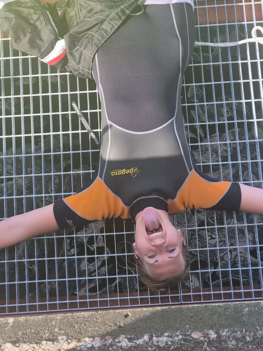 Madeleine Samuelsson lying on her back on a steel grating, sticking her tongue out